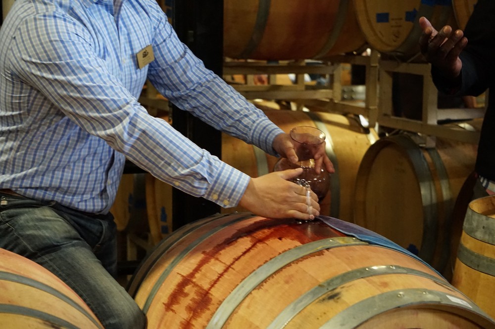 Jason Gorski Testing Red Wine from a Barrel